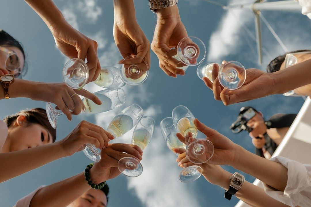 Venner skåler med glass under åpen himmel på en solrik dag